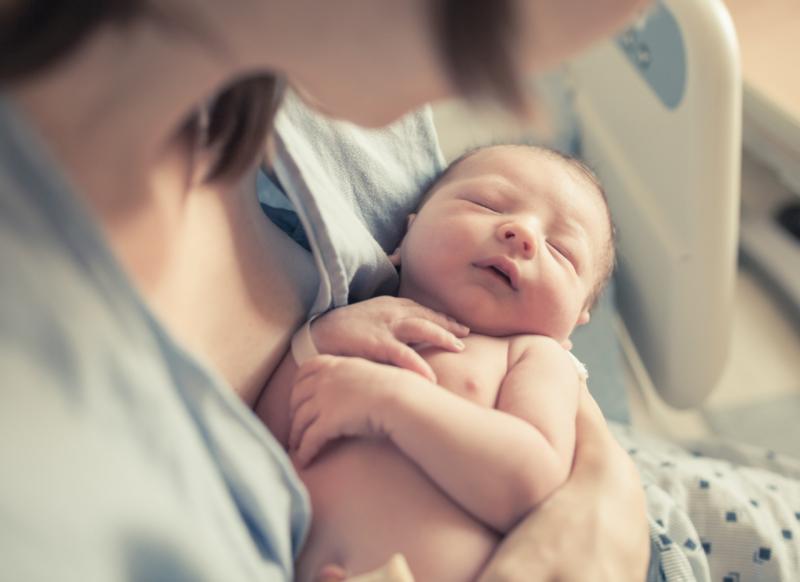 a newborn baby in the arms of a mother